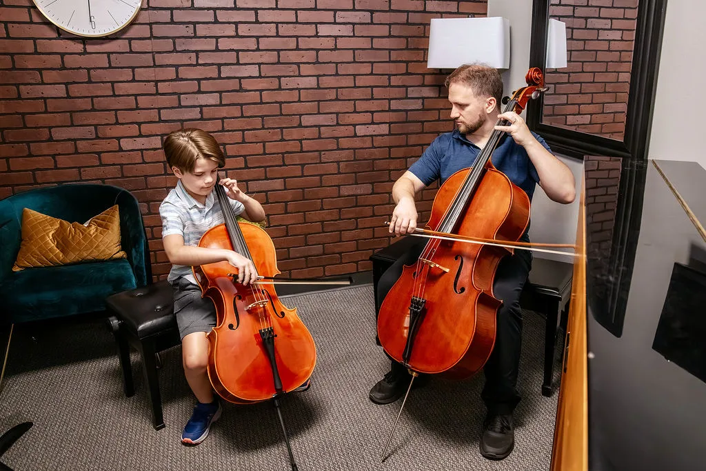 A student and teacher playing cello together in a chamber session.