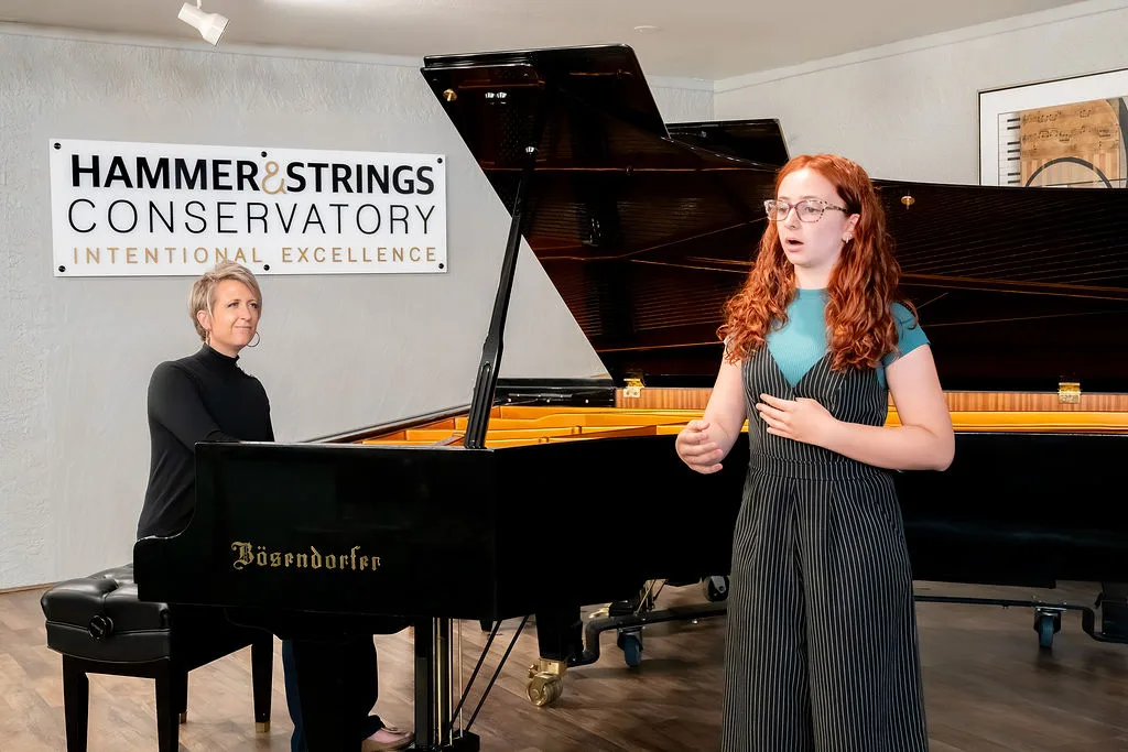 A singer and pianist performing beneath the Conservatory sign.