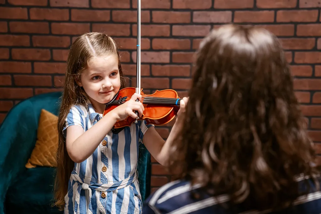 A student and her instructor during a private violin lesson.
