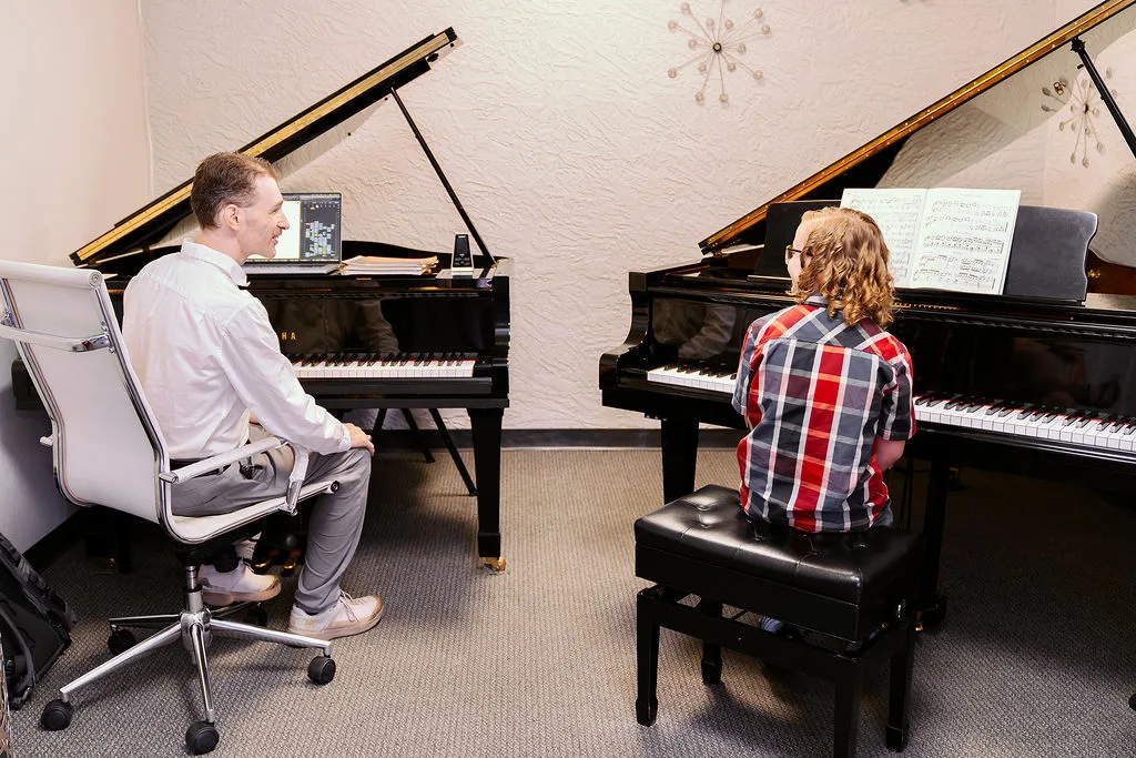 A teacher and student working together at the Conservatory pianos.