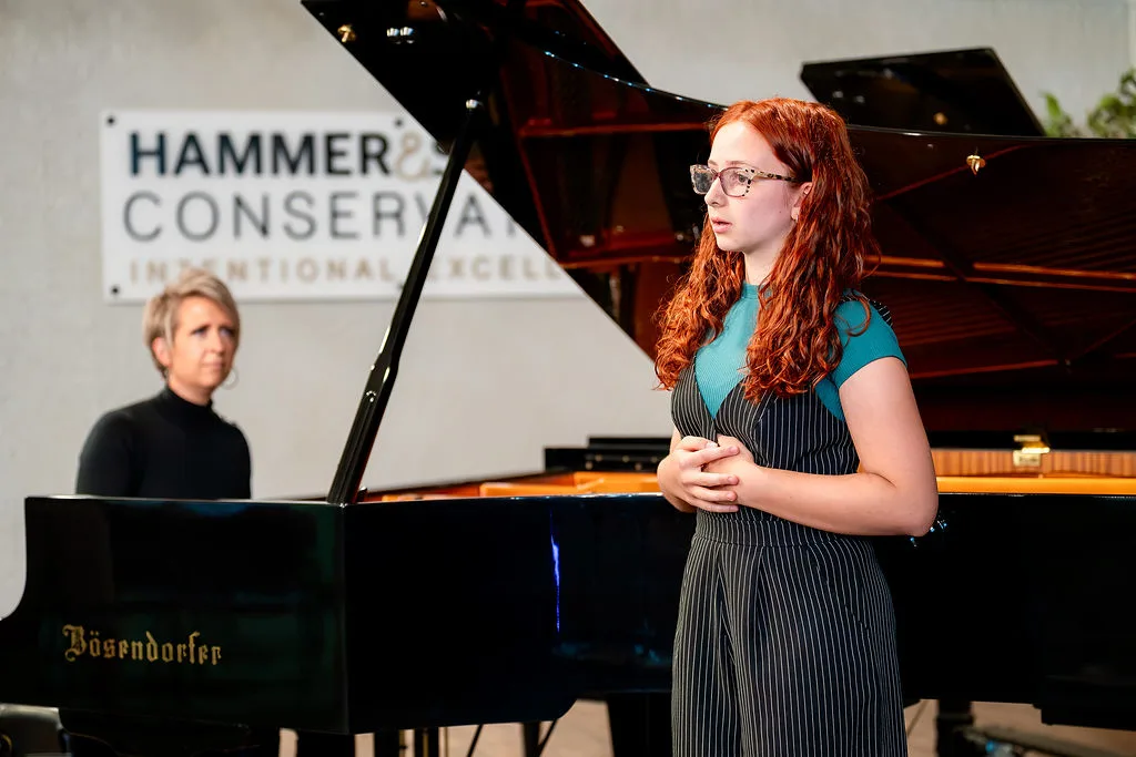 A recital in the hall with the Conservatory wall sign in view.